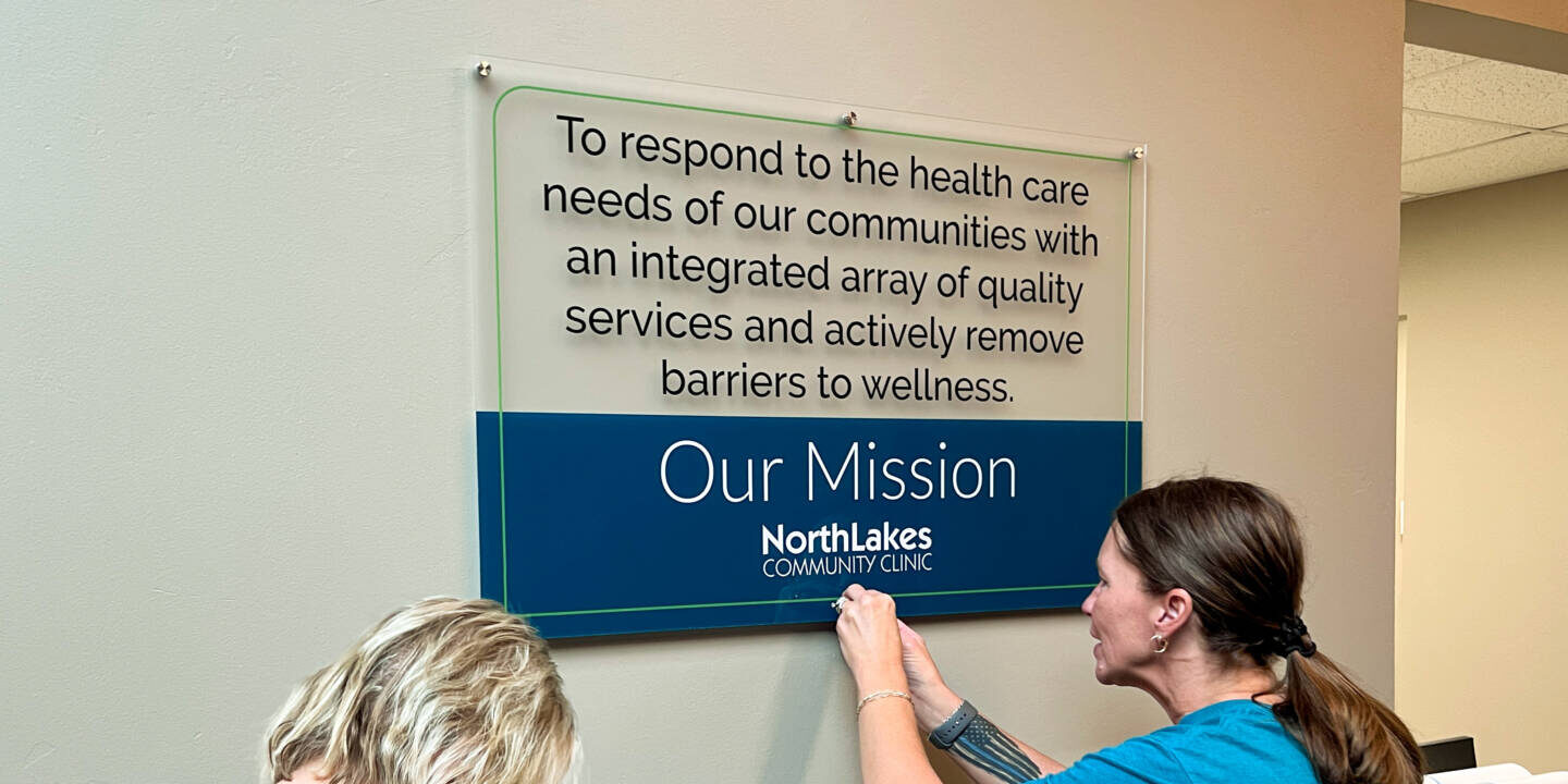 Employees hanging mission sign