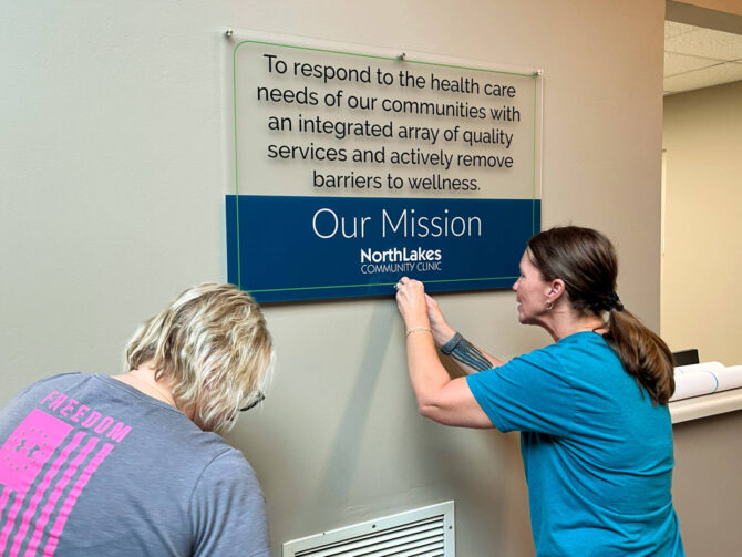 Clinic Move Employees hanging mission sign