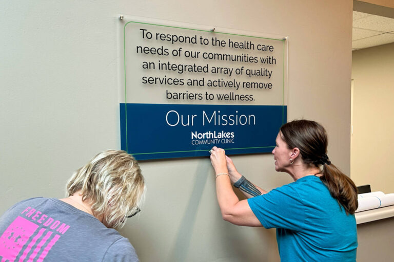 Employees hanging mission sign